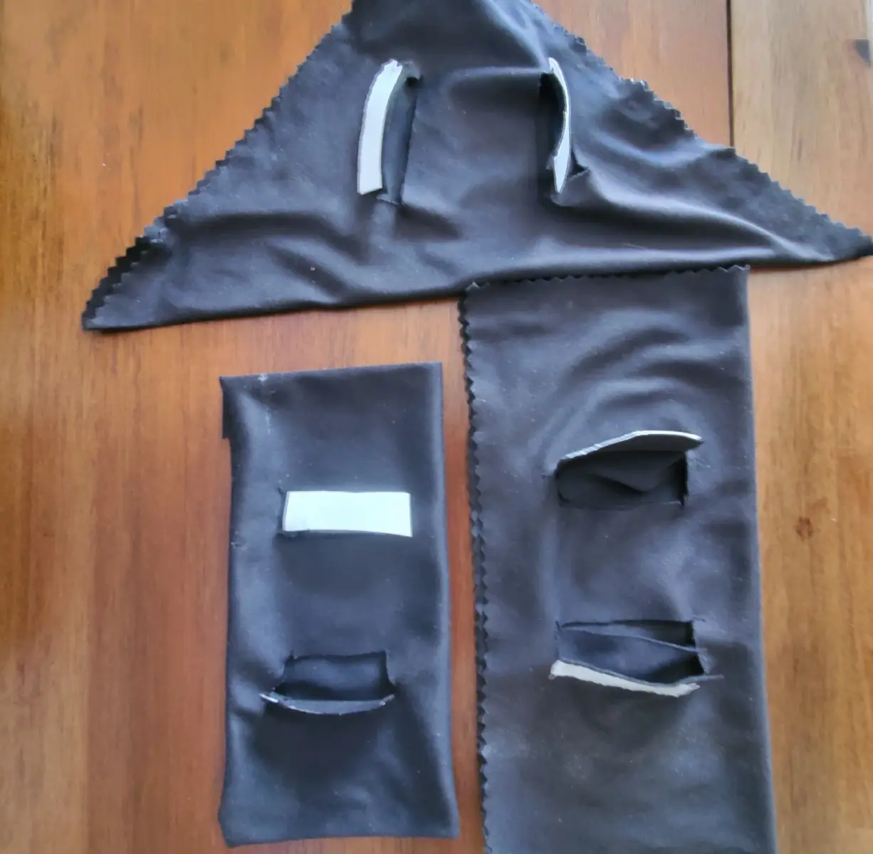Black fabric pieces with rectangular cutouts.