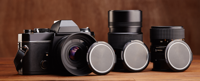 Vintage camera with three interchangeable lenses displayed.
